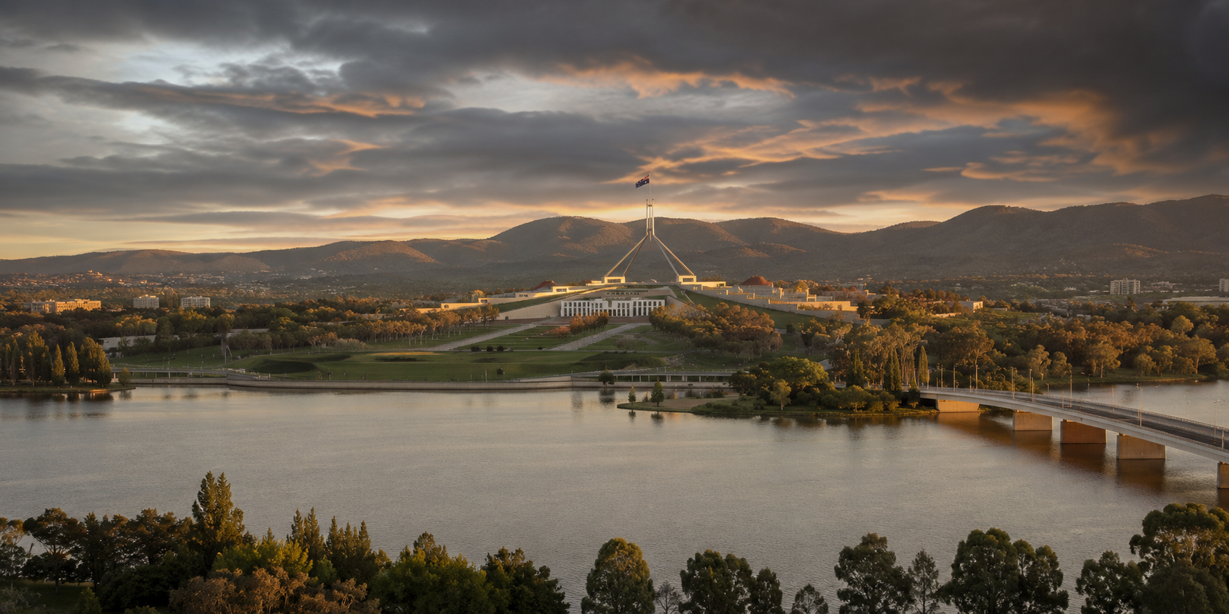 Canberra Parliament House at sunset across Lake Burley Griffin